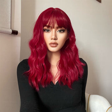 HAIRCUBE red wine spiral wave wig with long waves and bangs on a model wearing black top