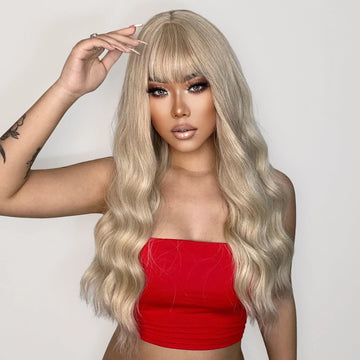 26 inch synthetic wig with bangs in blonde wavy style worn by woman in red top