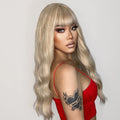 oneNonly 26 inch synthetic wig with bangs in blonde long wavy style on model wearing red top