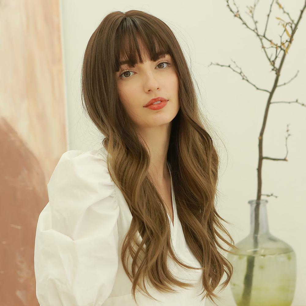 HAIRCUBE dark brown long curly synthetic wig styled with bangs on woman wearing white blouse