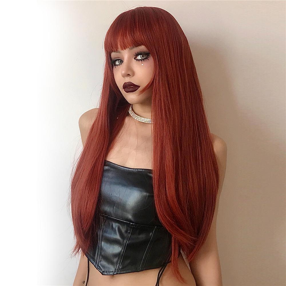 HAIRCUBE firebrick red long wavy wig styled with bangs on a model wearing black leather top