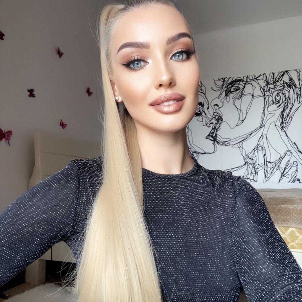Woman wearing a long synthetic ponytail extension with straight blonde hair styled in a high ponytail