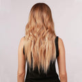 HAIRCUBE long wavy brown to ash blonde wig shown from the back on a model wearing a black top