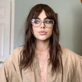 HAIRCUBE natural looking brown human hair wig worn by a woman with glasses and layered hairstyle