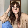 HAIRCUBE natural looking brown human hair wig styled on woman with glasses and casual clothing