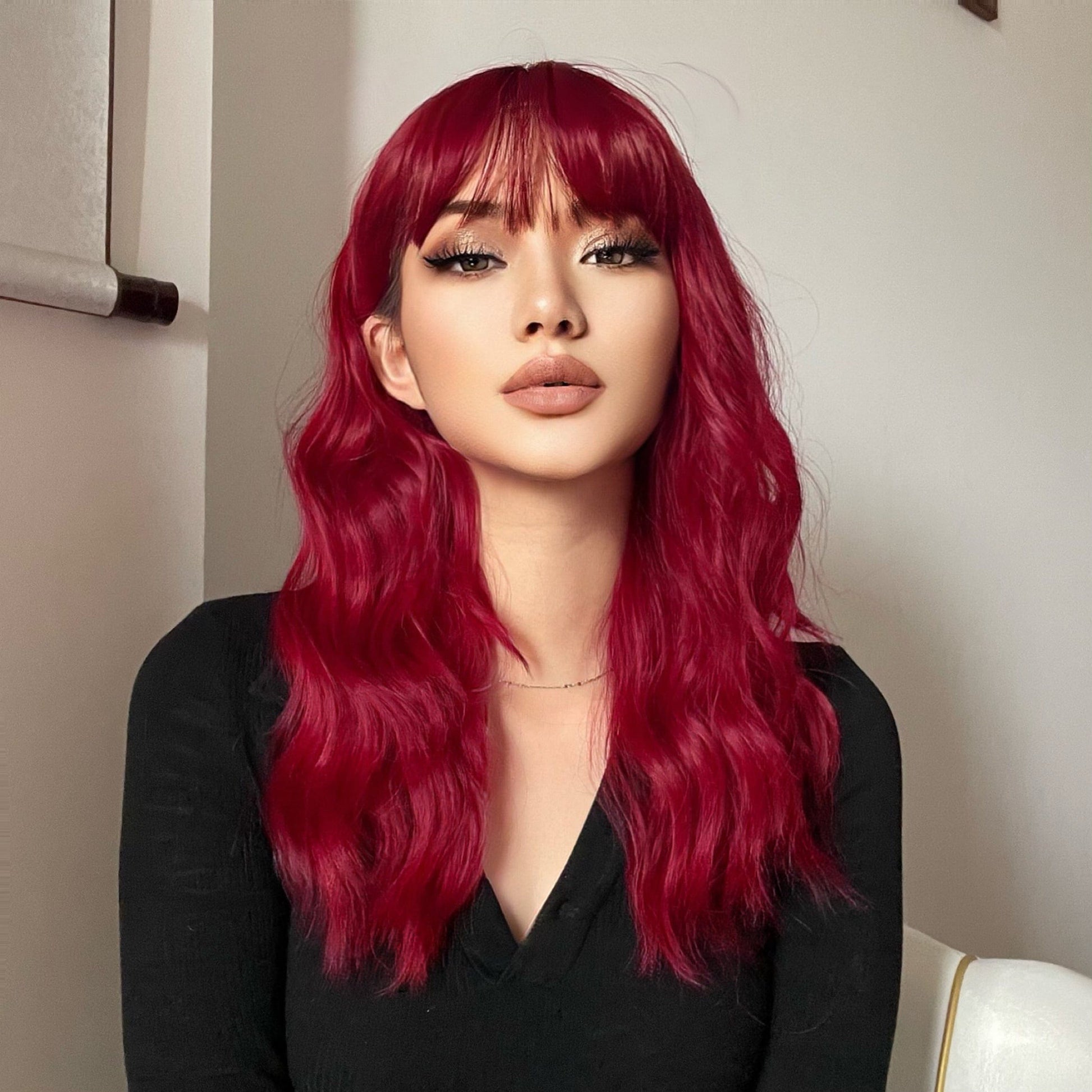 HAIRCUBE red wine spiral wave wig with long wavy hair and bangs on a woman wearing black