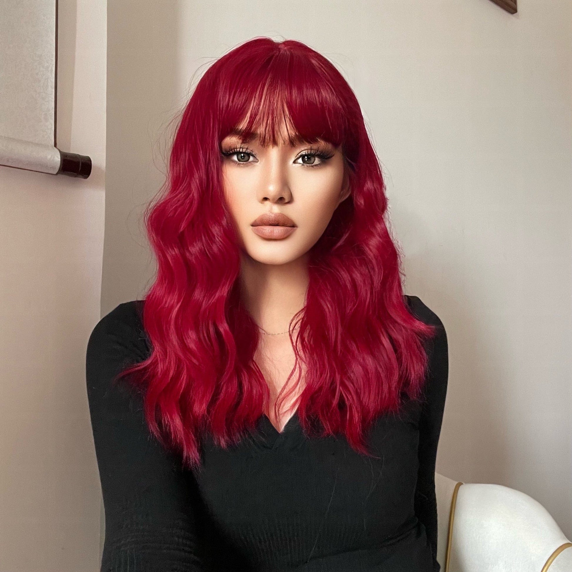 HAIRCUBE red wine spiral wave wig with long waves and bangs on a model wearing black top