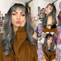 HAIRCUBE silver synthetic wig with bangs styled in loose waves worn by a woman in a brown jacket