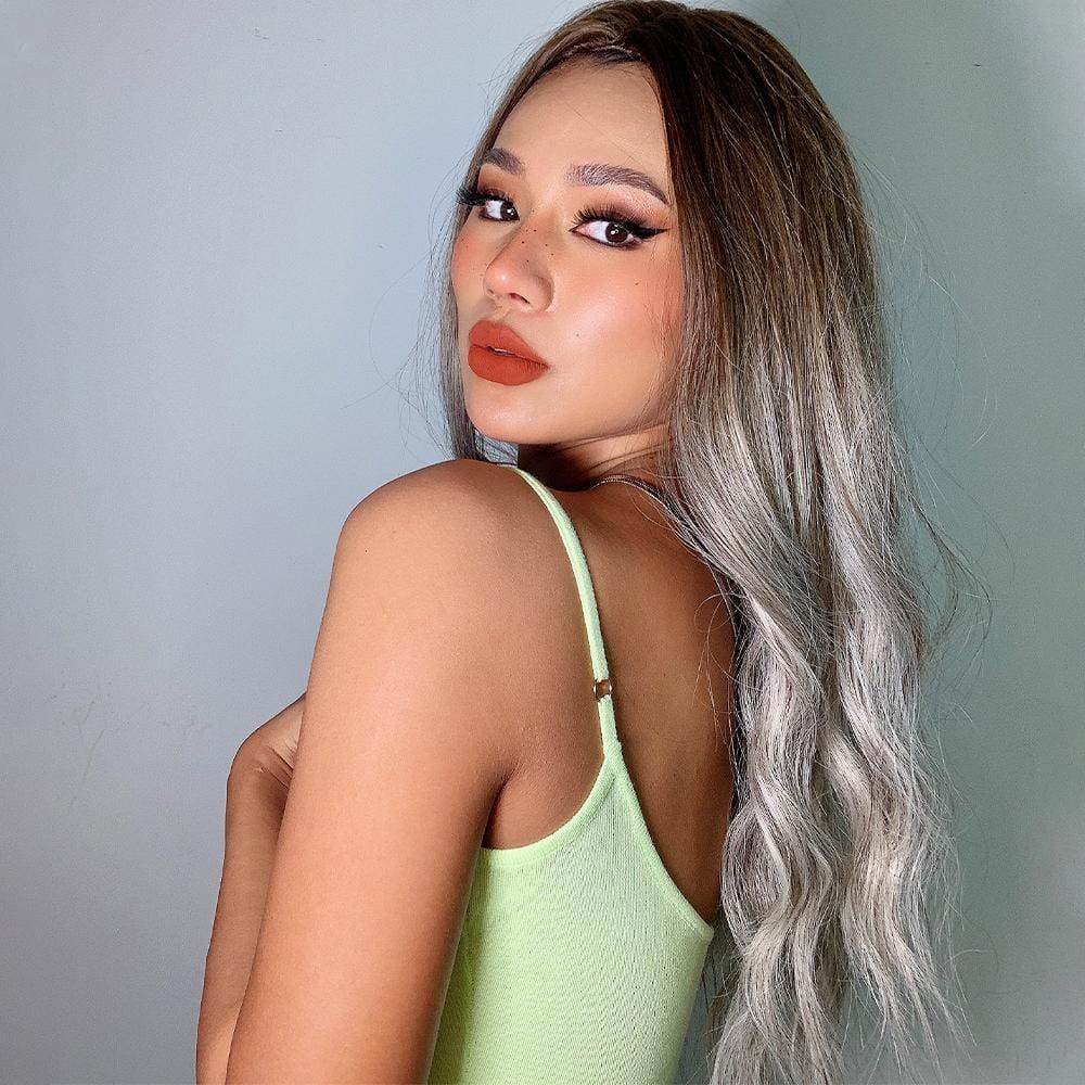 HAIRCUBE smokey grey synthetic wig styled with loose waves on a model wearing a green tank top