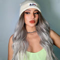 HAIRCUBE smokey grey synthetic wig styled in loose waves worn with a white beanie and green top