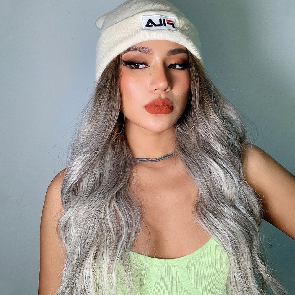 HAIRCUBE smokey grey synthetic wig styled in loose waves worn with a white beanie and green top