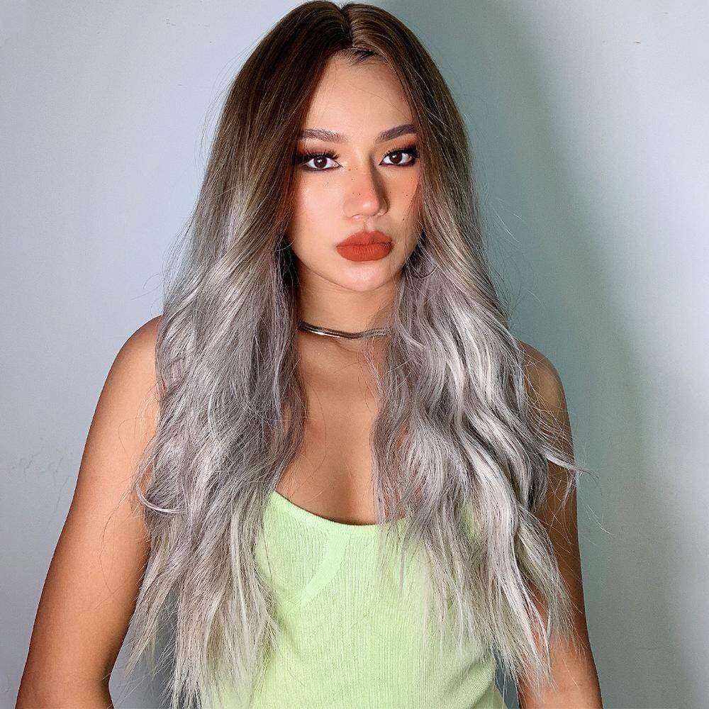HAIRCUBE smokey grey synthetic wig styled in long wavy hair on a woman wearing a light green top