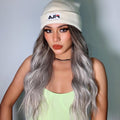 HAIRCUBE smokey grey synthetic wig with long wavy hair styled on a woman wearing a beanie