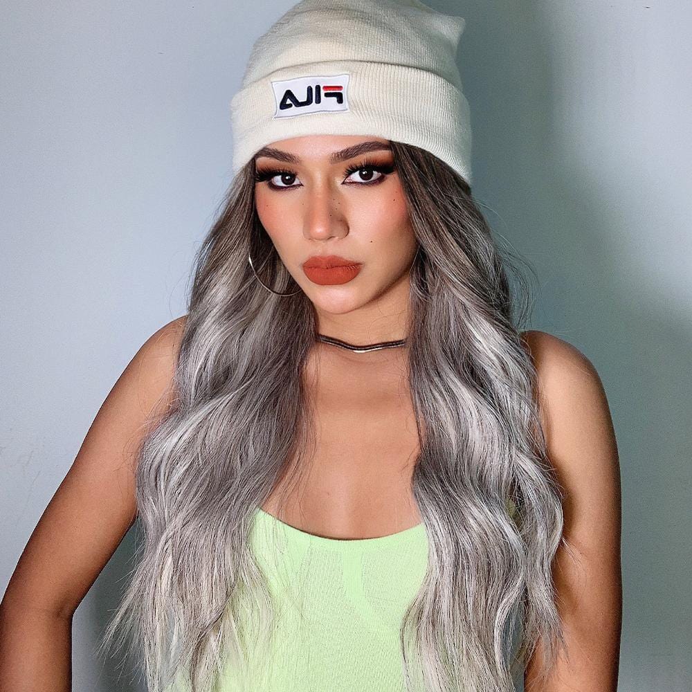 HAIRCUBE smokey grey synthetic wig with long wavy hair styled on a woman wearing a beanie
