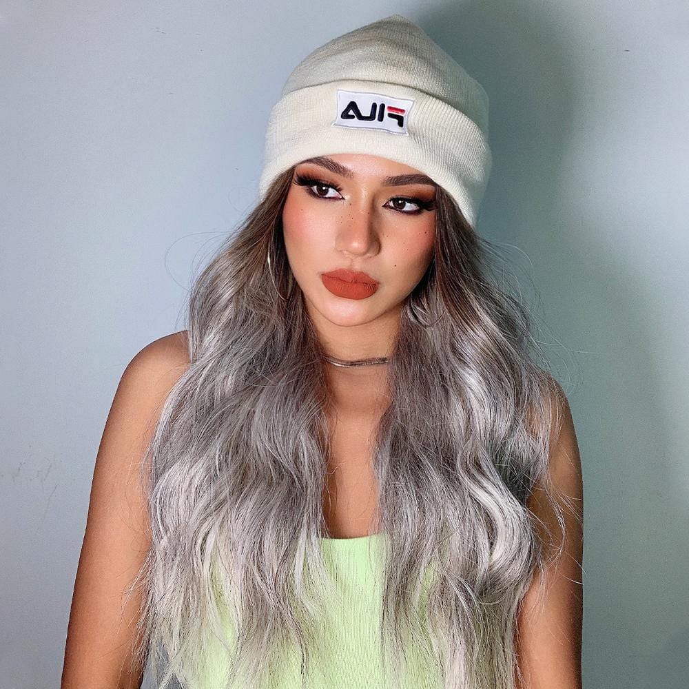HAIRCUBE smokey grey synthetic wig with long wavy strands worn with a white beanie