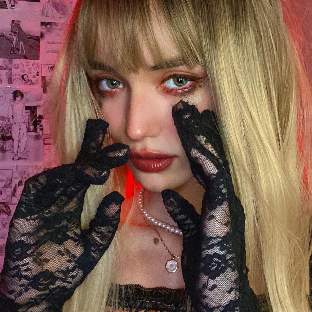 HAIRCUBE straight synthetic wig with bangs worn by model with long blonde hair and lace gloves