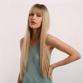 HAIRCUBE straight synthetic wig with bangs worn by woman in sleeveless teal top