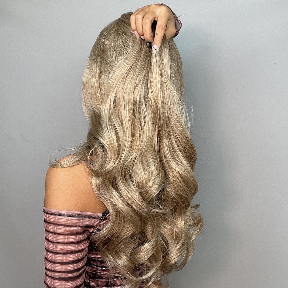Alan long blonde curly wig styled with voluminous soft curls on a woman wearing striped off shoulder top