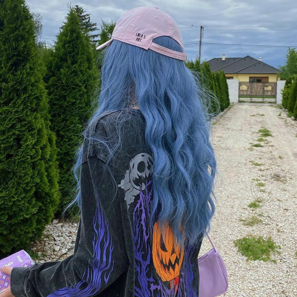 HAIRCUBE mermaid blue synthetic wig with long wavy hair worn under a pink cap outdoors