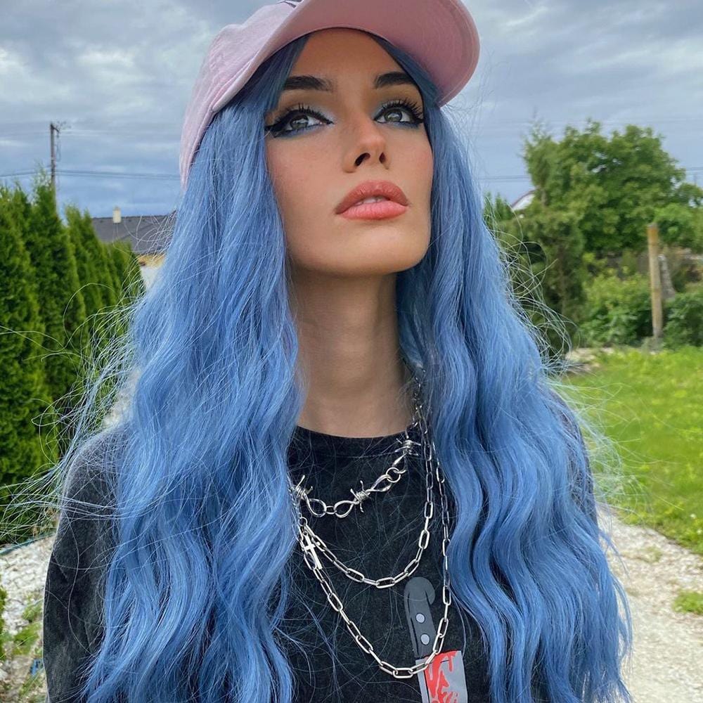 HAIRCUBE mermaid blue synthetic wig styled with long wavy hair worn with a pink cap