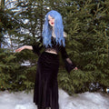 HAIRCUBE mermaid blue synthetic wig styled with long wavy hair on a model in a black dress outdoors