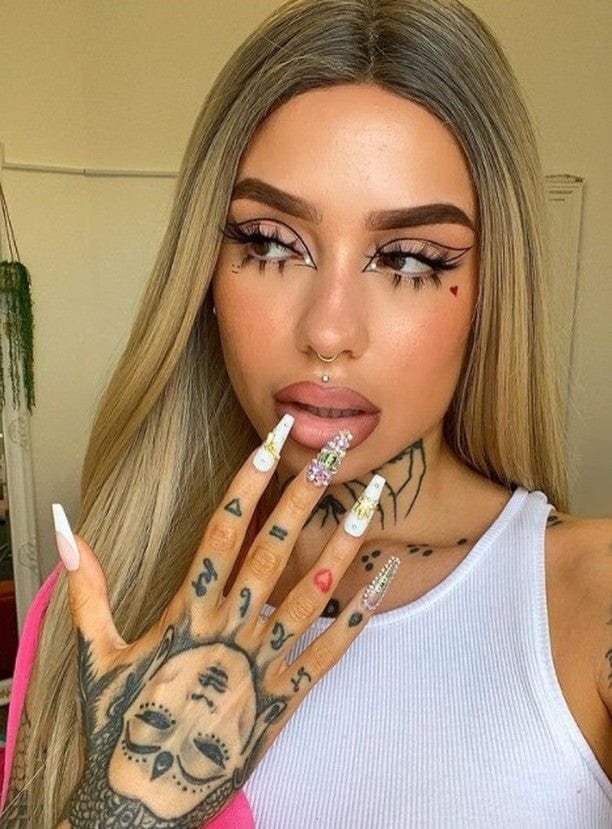 HAIRCUBE 21 inch straight lace front wig worn by a woman with bold makeup and detailed hand tattoos
